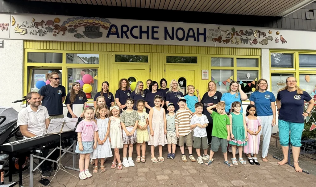 Vorschulkinder und pädagogische Fachkräfte vor der Kita Arche Noah
