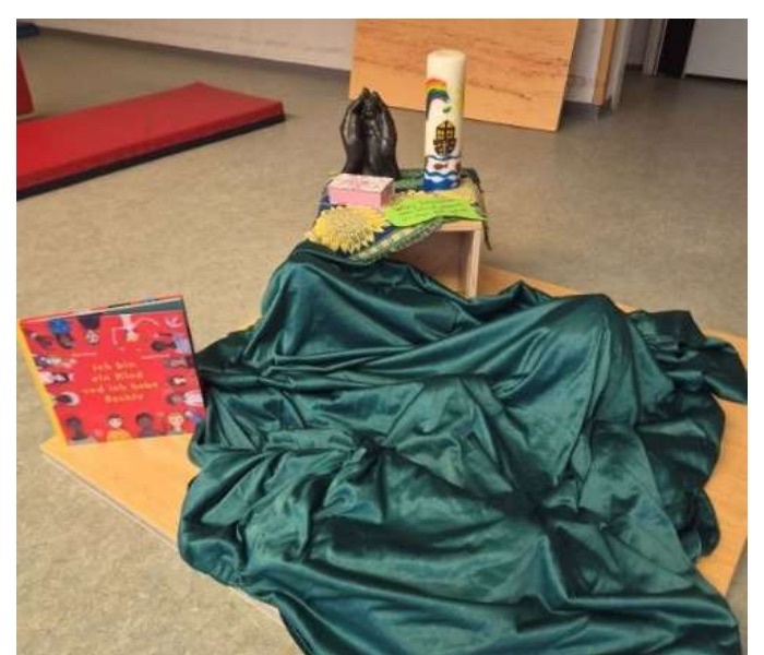 Vorbereiteter Andachtsplatz mit Tuch, Kerze und Materialien zur Weltkindertag-Woche